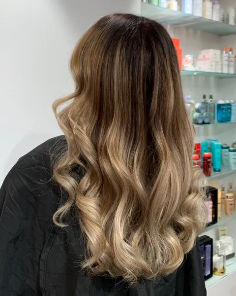 Balayage von dunklem Ansatz zu honigblonden Längen, gewellt