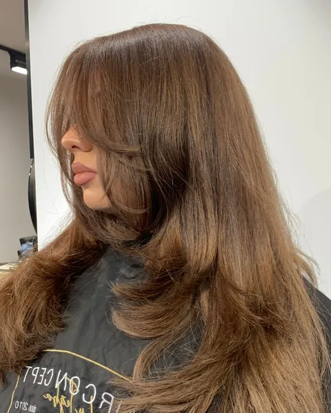 Karamellbraunes Haar mit Stufen und Curtain Bangs